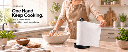 Original Amazon A+ black countertop paper-towel holder in kitchen while person kneads dough and tears towel, original text overlay